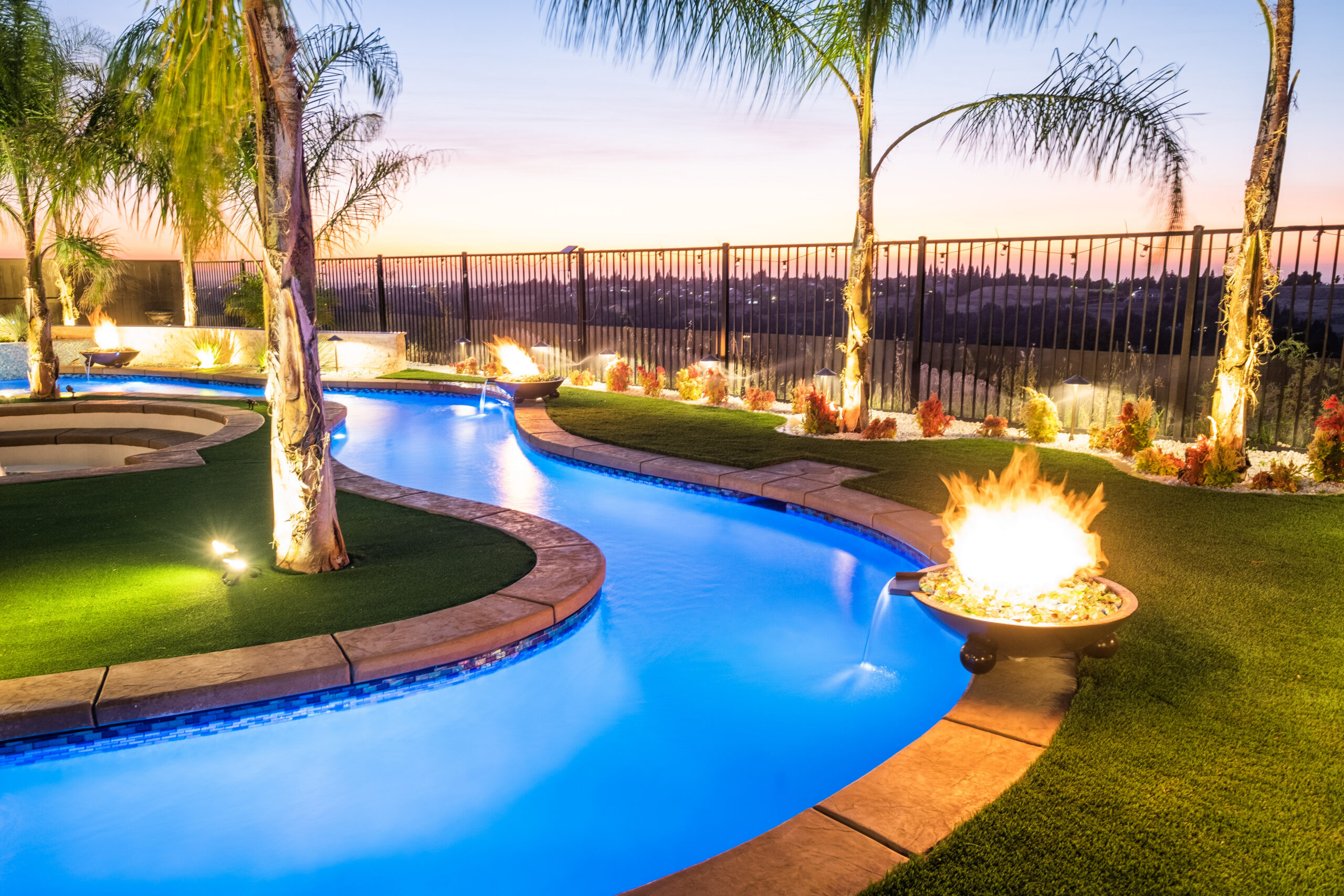 "Pool at night with a lit fire bowl and palm trees in Long Beach California"