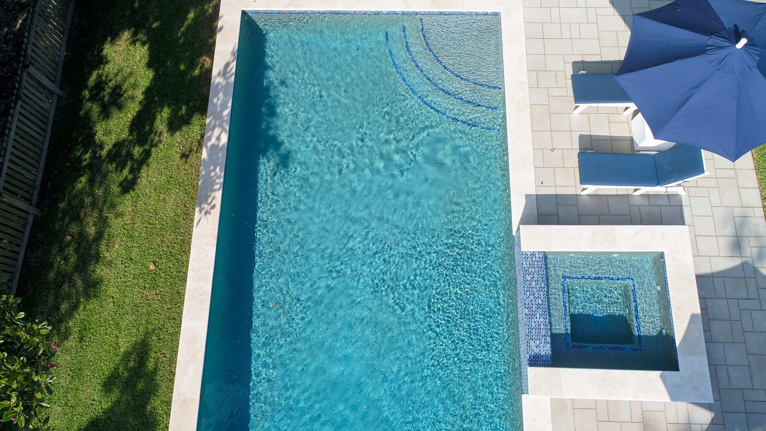 Clear pool with spa and umbrella