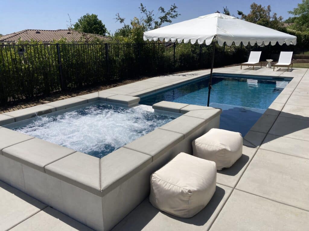 Poolside with hot tub and seating