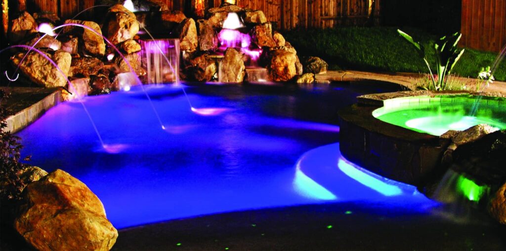 Illuminated pool with waterfalls and rocks