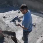 Man applying sealant in concrete pool construction site