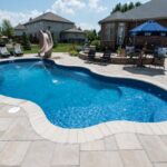 fiberglass Curved pool with slide and lounge chairs